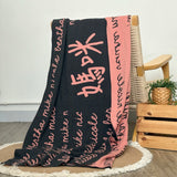 Customisable blanket with mum's name knitted in charcoal and dusty pink, personalized by TinyBitz.