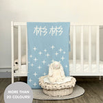 Knitted baby blanket in light blue and white with a twinkles pattern, customised with baby's name, made by TinyBitz.