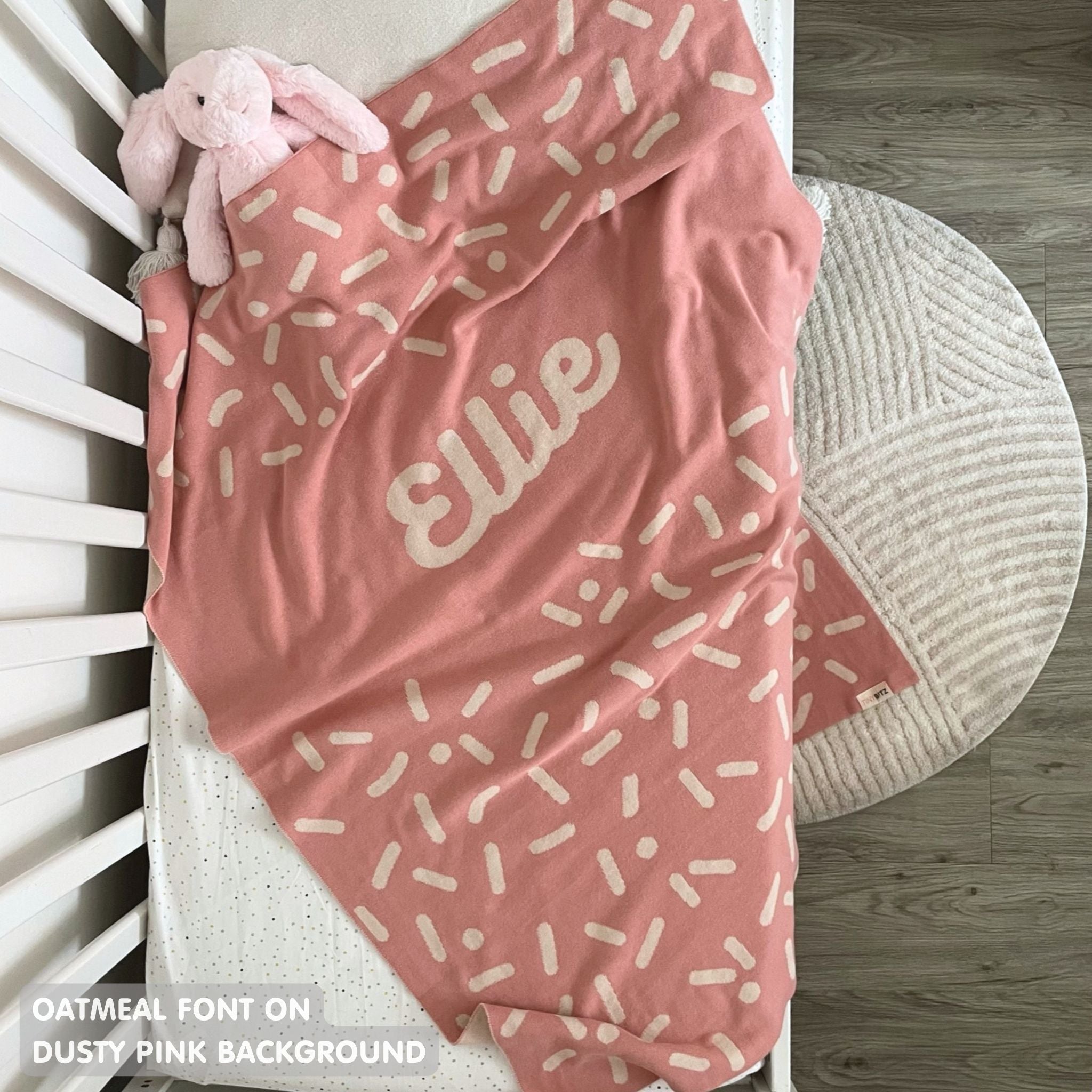 TinyBitz personalized baby name blanket, knitted in dusty pink and oatmeal with a confetti pattern, perfect baby shower gift!