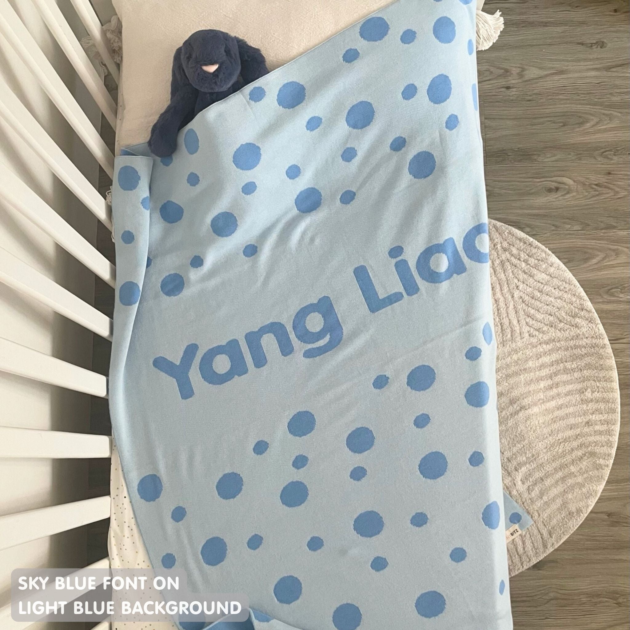 TinyBitz knitted name blanket in light blue and sky blue with a dot pattern, a lovely touch to decorate your baby's room!