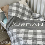 Knitted baby blanket in light grey and white with a check pattern, customised with baby's name, made by TinyBitz.