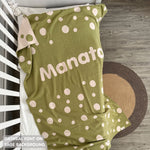 Knitted baby blanket in sage and oatmeal with a dot pattern, customised with baby's name, made by TinyBitz.