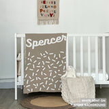 Knitted baby blanket in stone and white with a confetti pattern, customised with baby's name, made by TinyBitz.