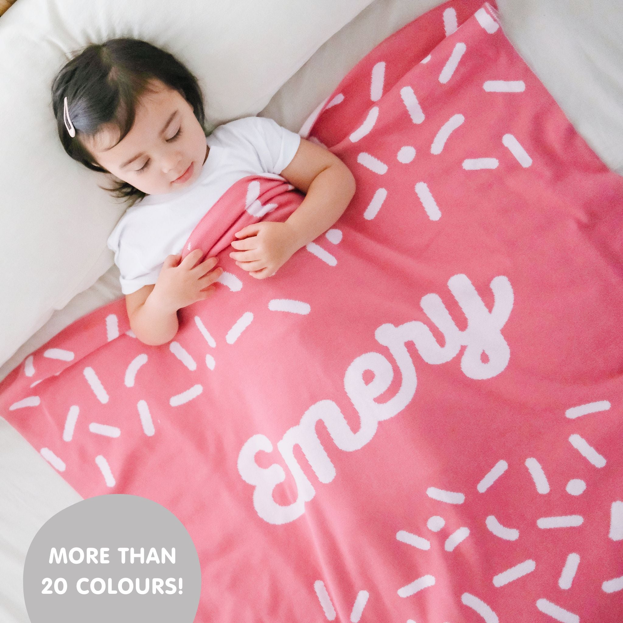 Knitted baby blanket in rose pink and white with a confetti pattern, customised with baby's name, made by TinyBitz.