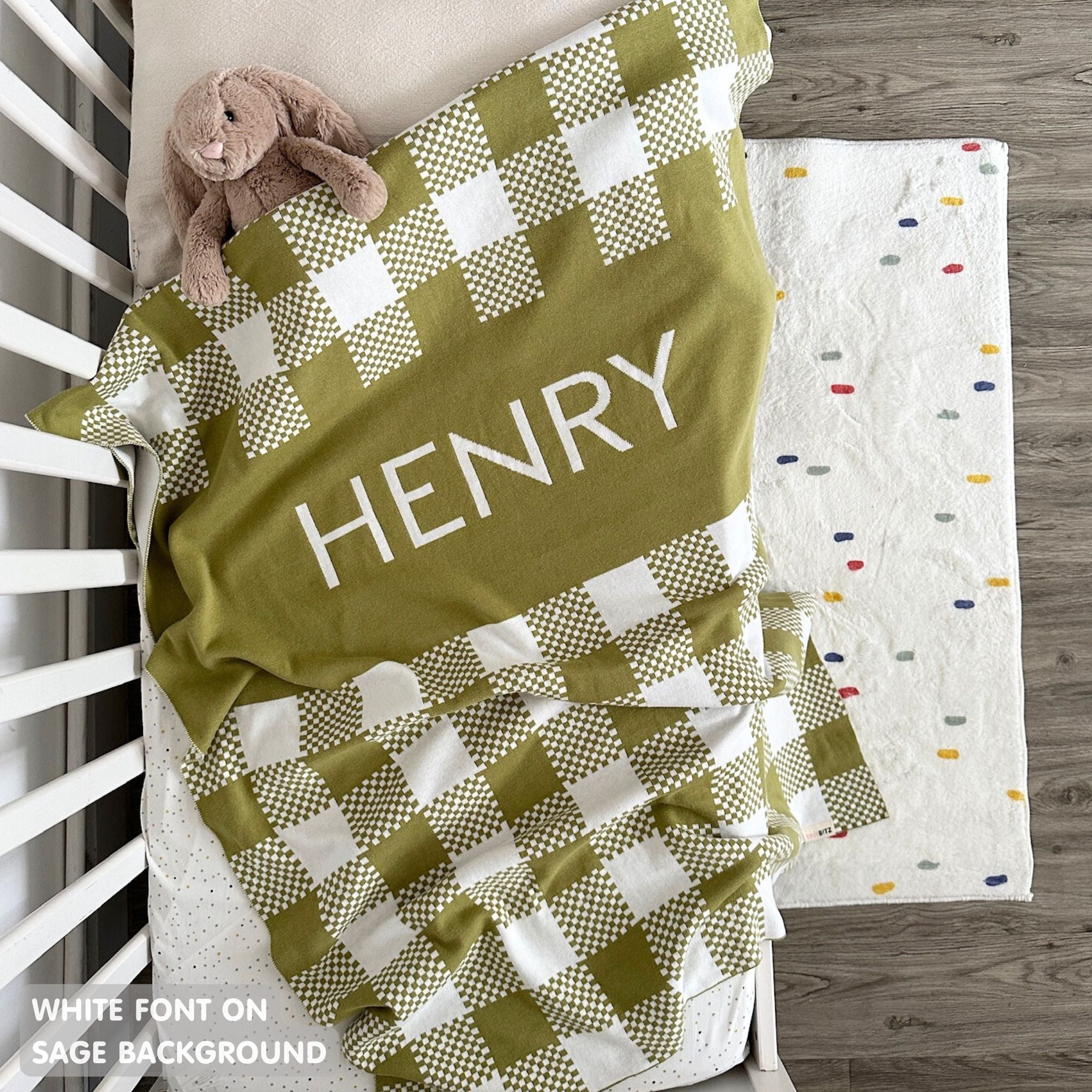 Cotton baby blanket with baby's name, knitted in sage and white with a check pattern, made by TinyBitz.