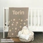 Knitted baby blanket in stone and oatmeal with a dot pattern, customised with baby's name, made by TinyBitz.