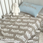 TinyBitz personalized knitted blanket in stone background, customized with baby's name and made from 100% cotton.