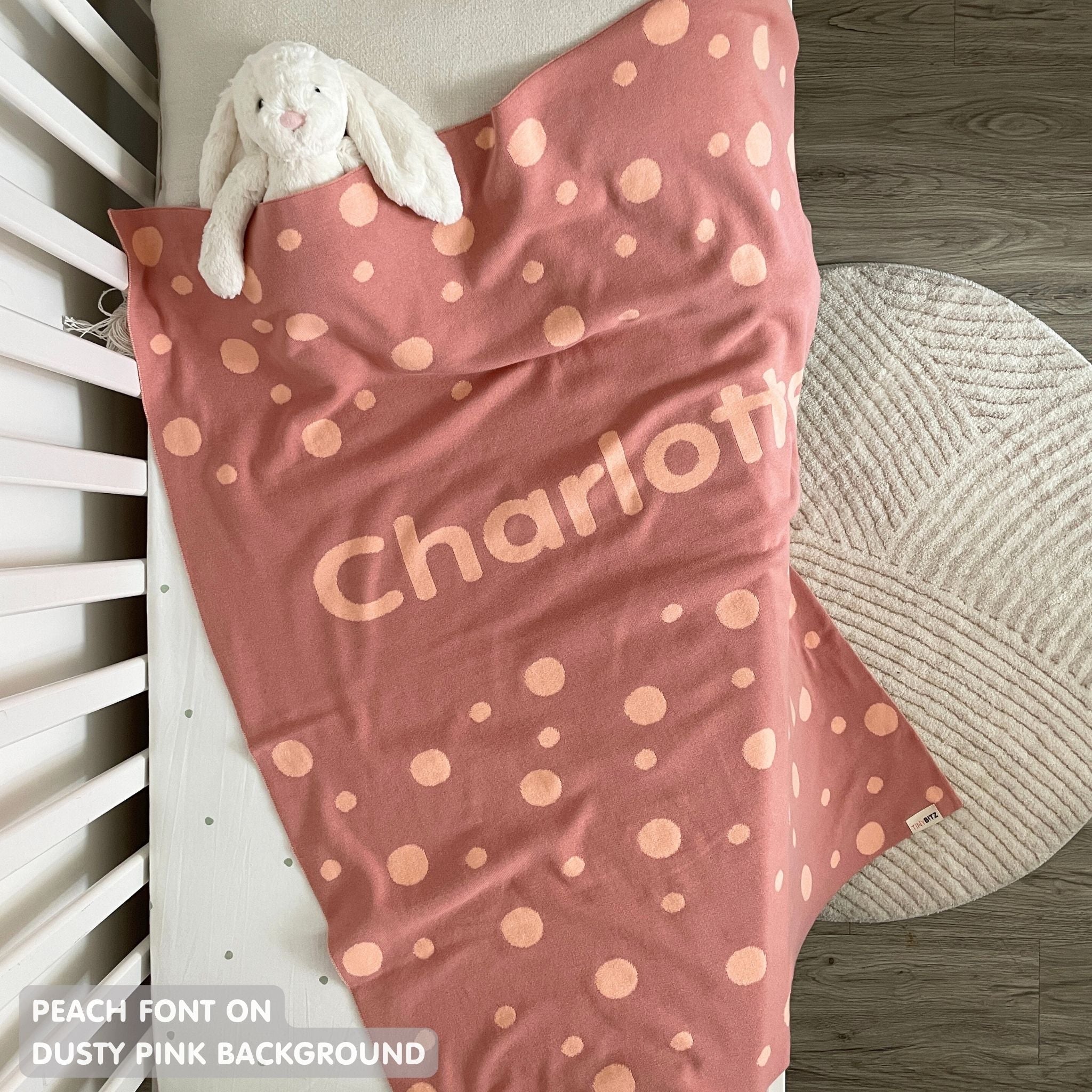TinyBitz personalized baby name blanket, knitted in dusty pink and peach with a dot pattern, perfect baby shower gift!