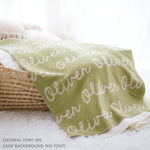 TinyBitz personalized knitted blanket in sage background, customized with baby's name and made from 100% cotton.