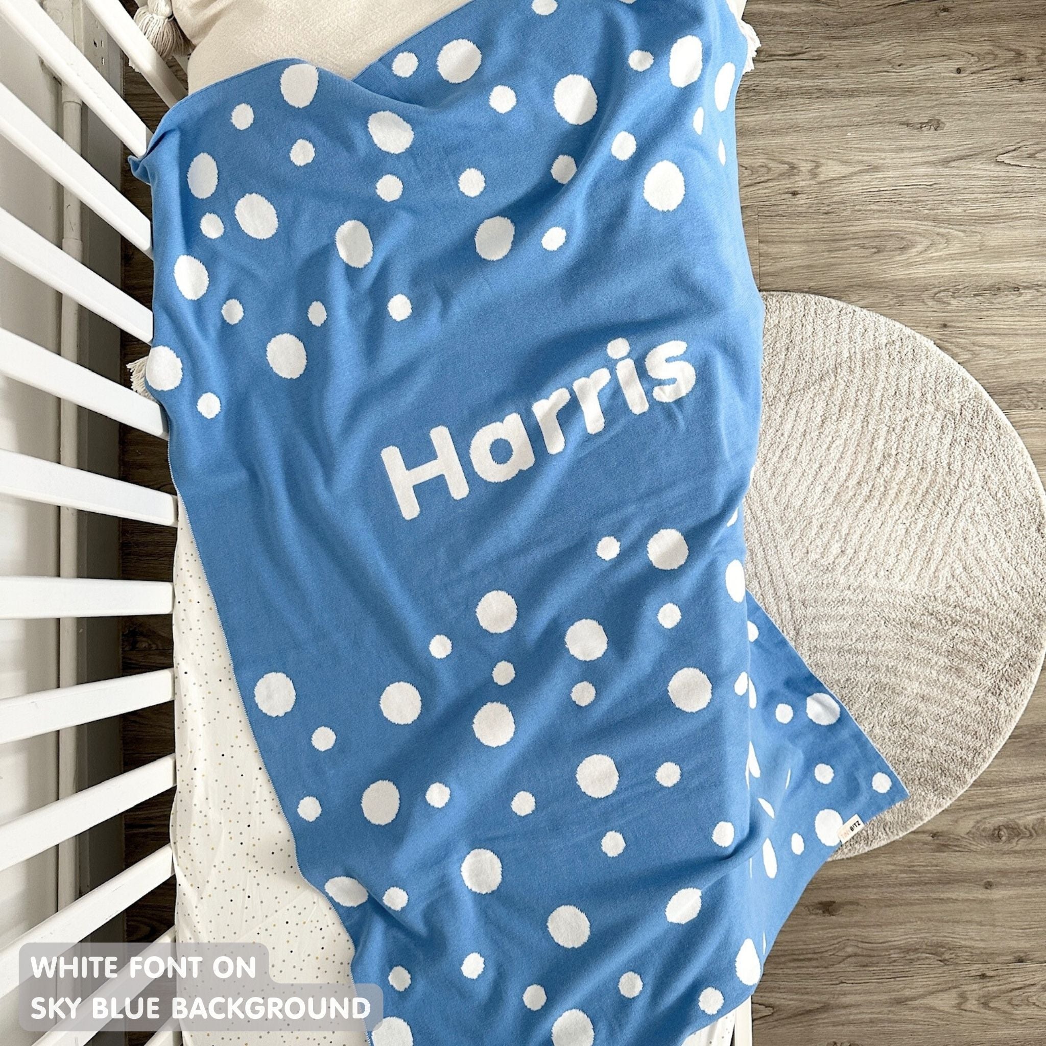 Knitted baby blanket in sky blue and white with a dot pattern, customised with baby's name, made by TinyBitz.